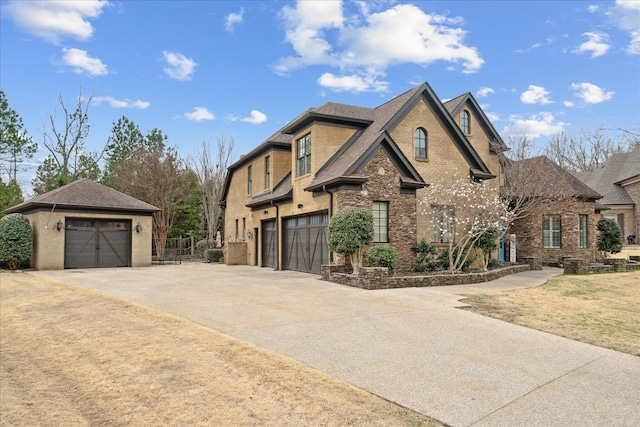 view of front of house featuring brick siding, an outbuilding, a garage, and roof with shingles