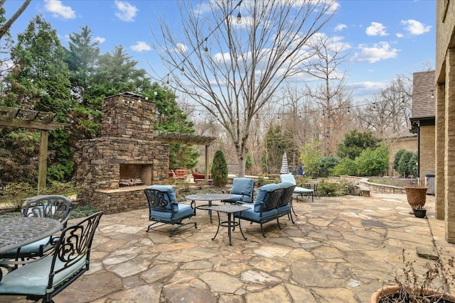 view of patio / terrace with outdoor dining area and an outdoor stone fireplace