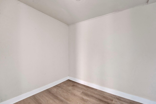 spare room featuring wood finished floors and baseboards