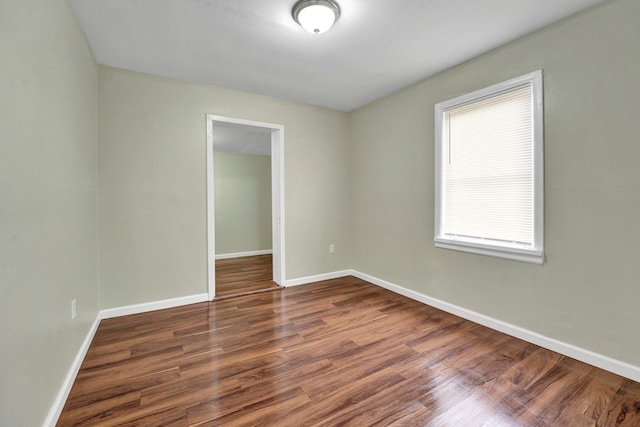 empty room with baseboards and wood finished floors