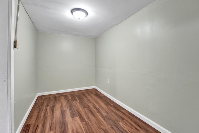 unfurnished room with baseboards and dark wood finished floors