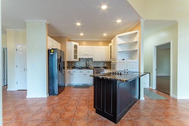 kitchen with refrigerator with ice dispenser, open shelves, a sink, stainless steel dishwasher, and white cabinetry