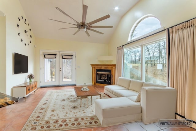 living room featuring ceiling fan, french doors, a fireplace, tile patterned floors, and high vaulted ceiling