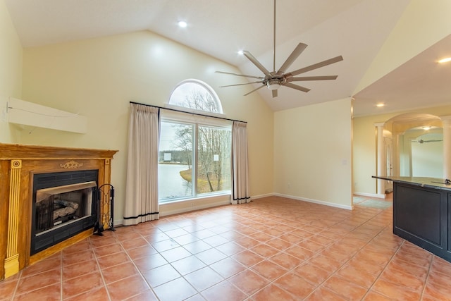 unfurnished living room with baseboards, a fireplace, arched walkways, light tile patterned flooring, and a ceiling fan