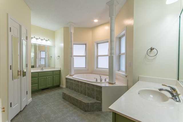 bathroom with a bath, tile patterned floors, two vanities, and a sink