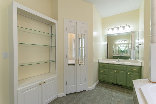 full bathroom featuring tile patterned flooring, a washtub, vanity, and baseboards