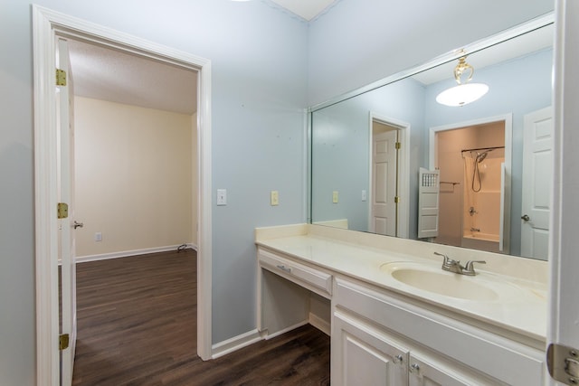 bathroom with baseboards, wood finished floors, and vanity