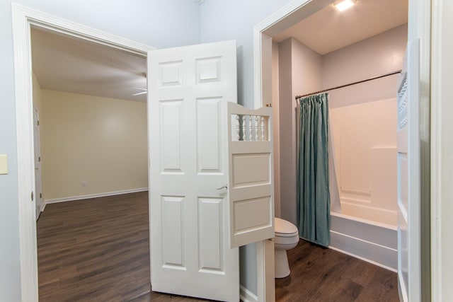 full bath with shower / bathtub combination with curtain, baseboards, toilet, and wood finished floors