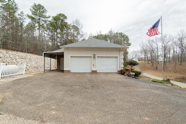 garage with driveway and fence