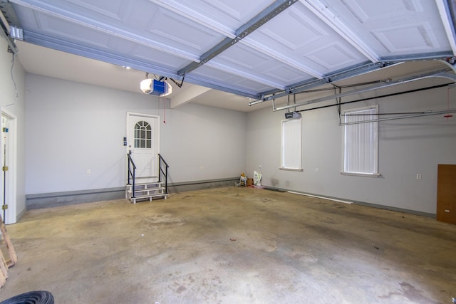 garage featuring a garage door opener and baseboards