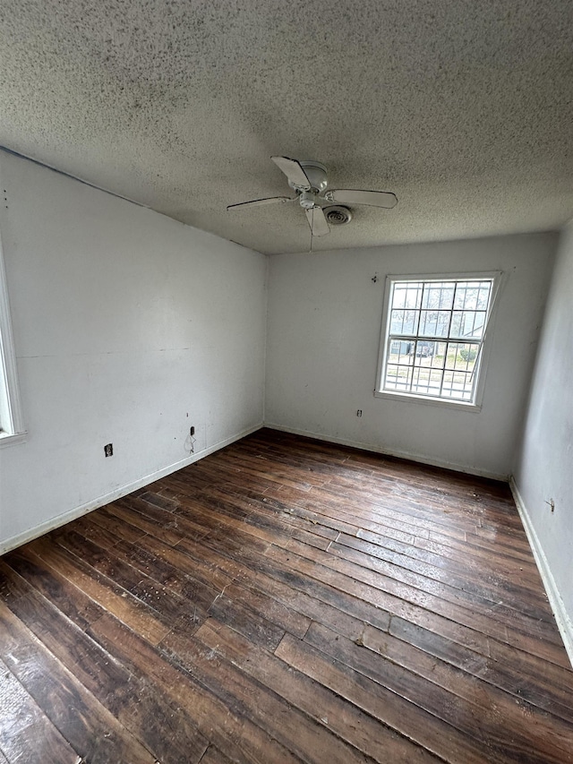 empty room featuring baseboards, a textured ceiling, ceiling fan, and wood-type flooring