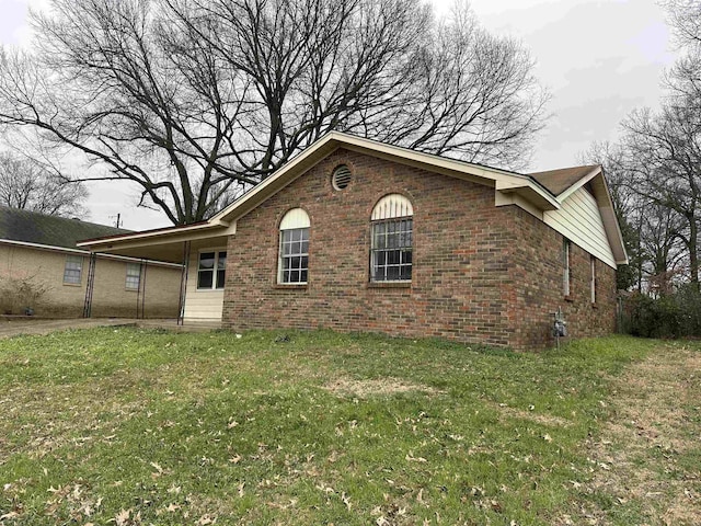 view of front of home with brick siding and a front lawn