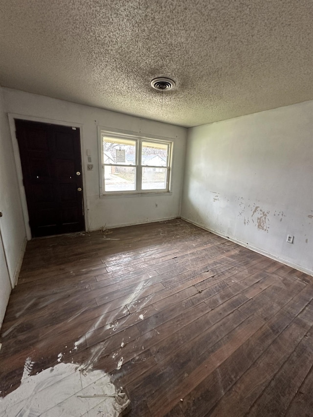 entrance foyer featuring dark wood finished floors, visible vents, and a textured ceiling