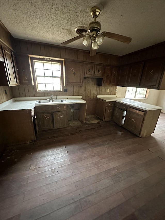 kitchen featuring a textured ceiling, dark wood-type flooring, light countertops, and a sink