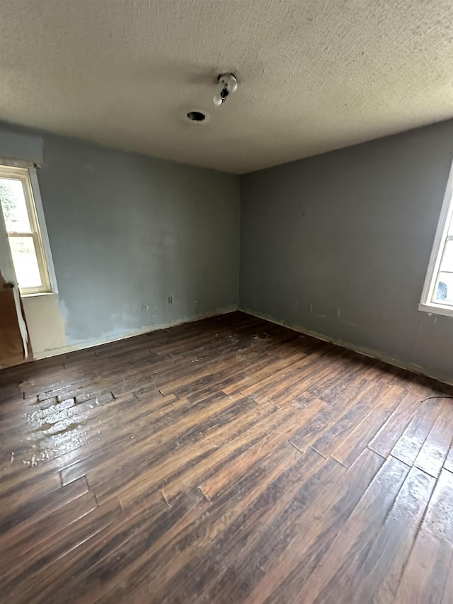 spare room with dark wood-type flooring and a textured ceiling