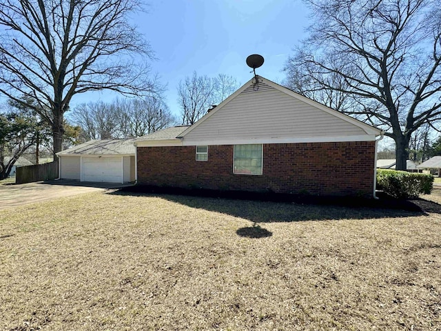 view of property exterior featuring concrete driveway, an attached garage, brick siding, and a yard