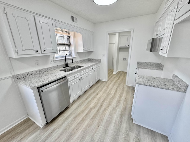 kitchen featuring light wood finished floors, visible vents, baseboards, stainless steel dishwasher, and a sink