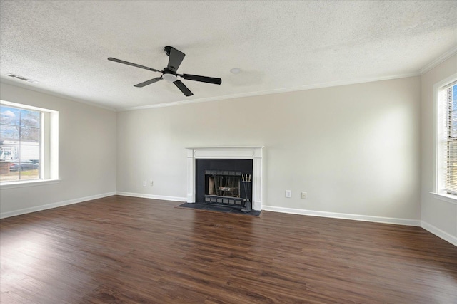 unfurnished living room with visible vents, a fireplace with flush hearth, ornamental molding, and dark wood-style flooring