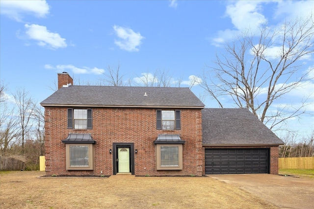 colonial house with brick siding, a front lawn, concrete driveway, a chimney, and a garage