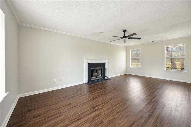 unfurnished living room with dark wood-type flooring, a fireplace with flush hearth, baseboards, and a textured ceiling