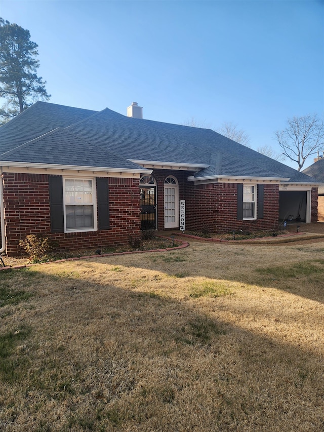 single story home featuring a front lawn, a chimney, brick siding, and a shingled roof