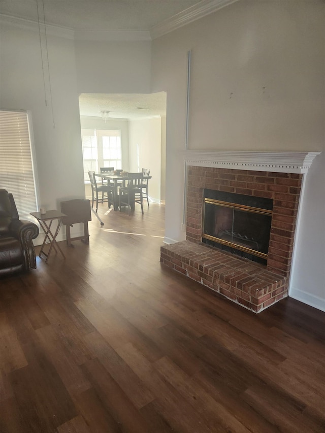 living area featuring wood finished floors, ornamental molding, and a fireplace