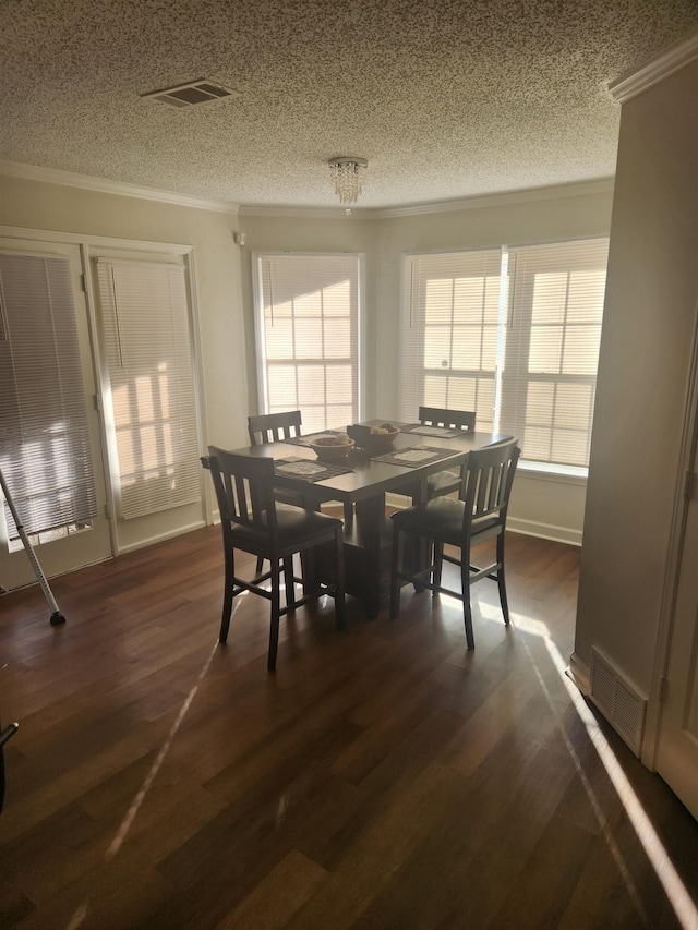 dining space with dark wood-type flooring, plenty of natural light, visible vents, and ornamental molding