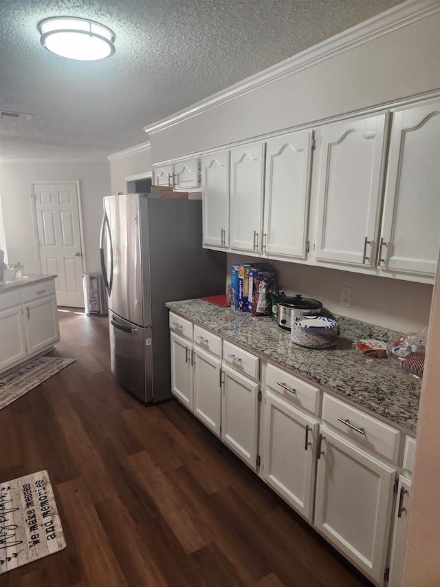 kitchen featuring dark wood-style floors, visible vents, ornamental molding, and white cabinets