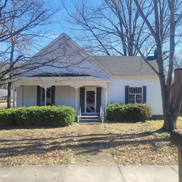 view of front facade featuring covered porch and a shingled roof