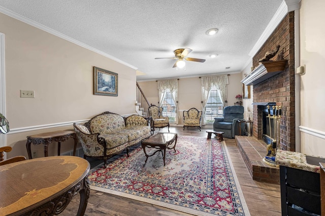 living room featuring a brick fireplace, wood finished floors, a ceiling fan, and ornamental molding