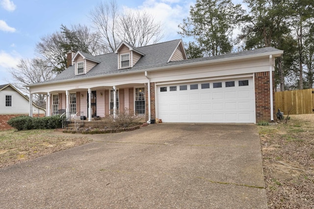 cape cod house with driveway, fence, covered porch, an attached garage, and brick siding