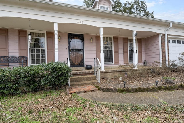 property entrance with an attached garage and covered porch