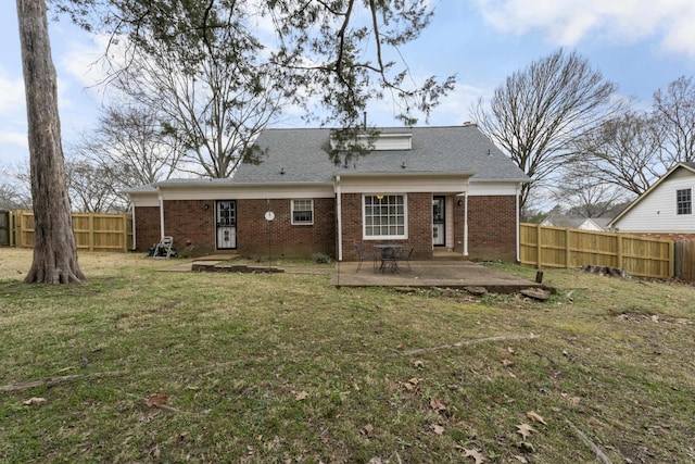 rear view of property with a patio, a yard, fence private yard, and brick siding