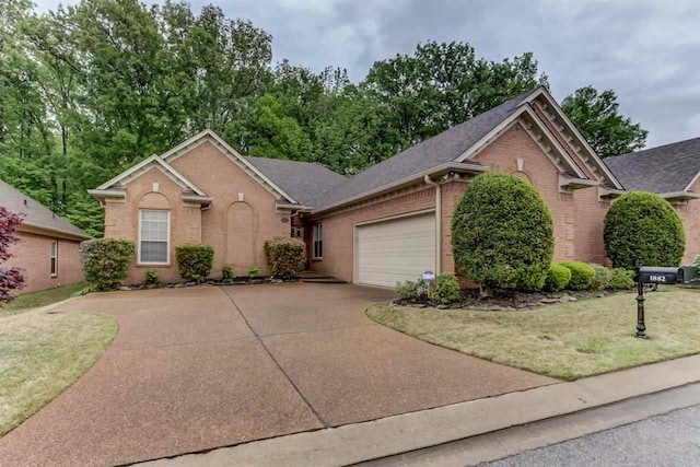 ranch-style house featuring brick siding, driveway, a front lawn, and a garage