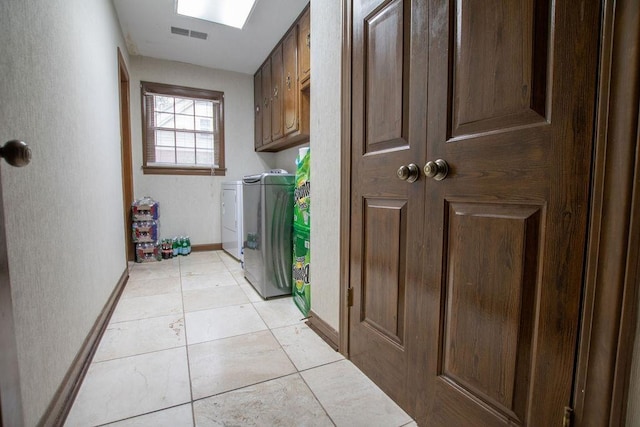 washroom with visible vents, cabinet space, light tile patterned floors, baseboards, and washing machine and clothes dryer