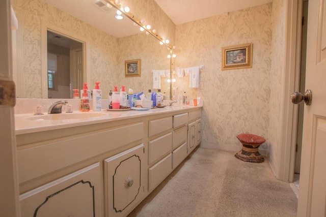 full bathroom with double vanity, wallpapered walls, baseboards, and a sink