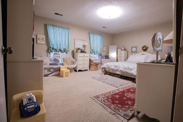 bedroom with visible vents, a textured ceiling, and carpet flooring