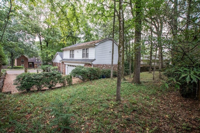 view of side of home with brick siding and an attached garage