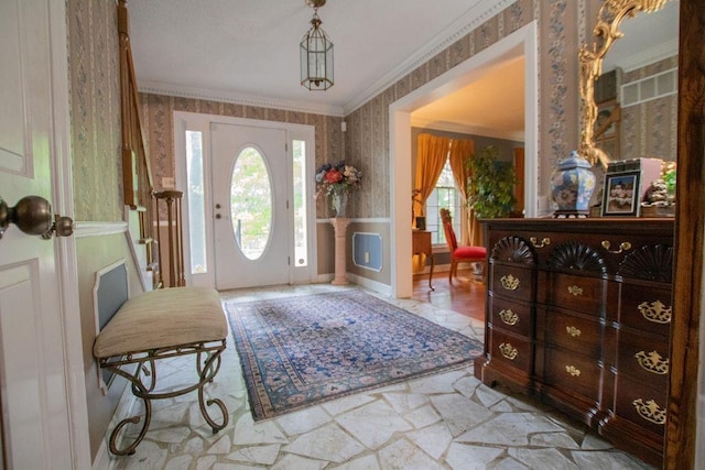 foyer entrance featuring wallpapered walls, crown molding, and plenty of natural light