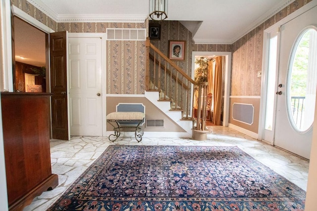 foyer entrance with wallpapered walls, visible vents, marble finish floor, and ornamental molding