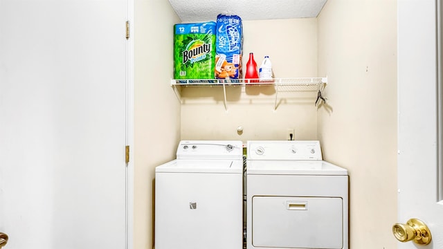 washroom with separate washer and dryer, laundry area, and a textured ceiling