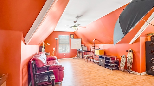 interior space with visible vents, ceiling fan, baseboards, lofted ceiling, and wood finished floors