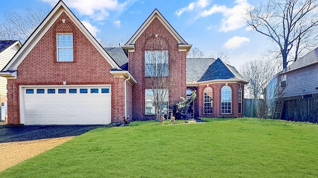 traditional-style house with driveway, a front lawn, fence, roof with shingles, and brick siding