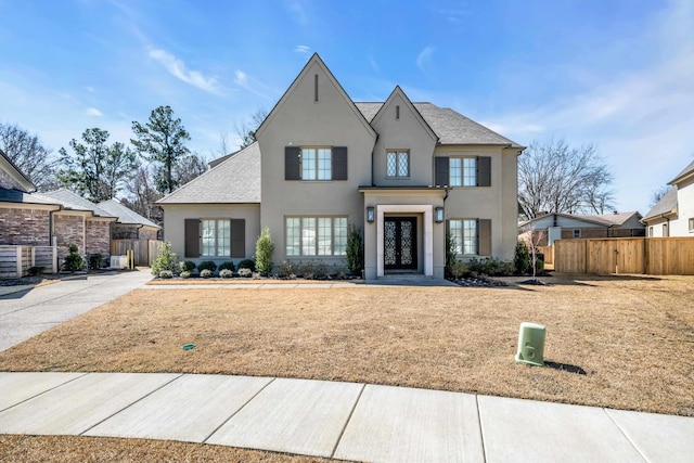 french country inspired facade featuring stucco siding and fence