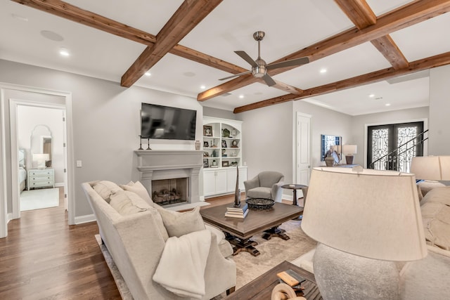 living area with dark wood-type flooring, baseboards, beam ceiling, recessed lighting, and a fireplace