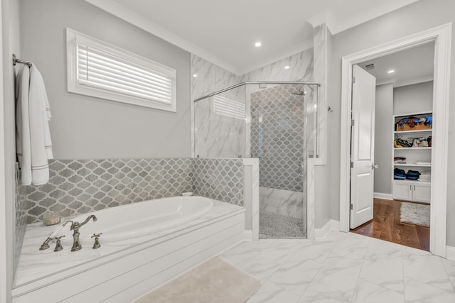 bathroom with a walk in closet, marble finish floor, a stall shower, crown molding, and a bath