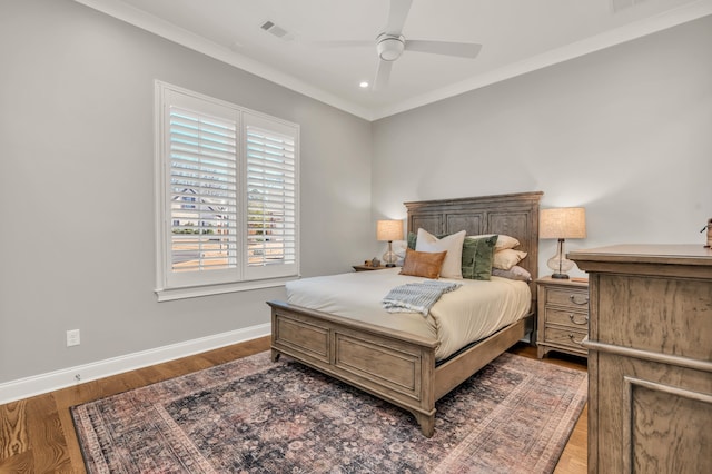 bedroom featuring wood finished floors, baseboards, visible vents, recessed lighting, and ornamental molding