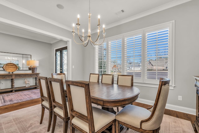 dining area with visible vents, ornamental molding, wood finished floors, an inviting chandelier, and baseboards