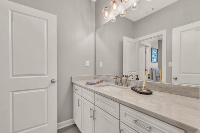 bathroom with visible vents, vanity, and baseboards