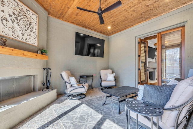 living room featuring ceiling fan, wood ceiling, and an outdoor brick fireplace